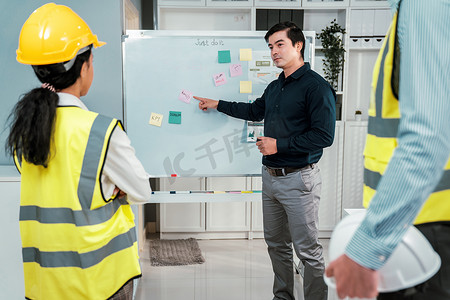 一组投资者和称职的工程师在白板上集思广益。