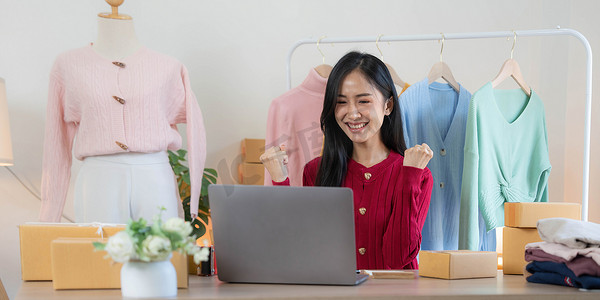 亚洲中小企业女商人在家里使用笔记本电脑检查客户订购的在线运输箱。