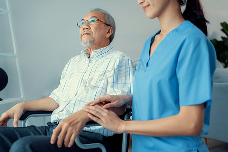 有爱心的护士和家里坐在轮椅上心满意足的老人。
