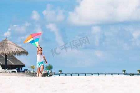 放风筝的人摄影照片_小女孩在沙滩上用碧绿的水放风筝