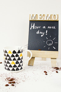 文字早上好摄影照片_咖啡豆，杯子，黑板上的文字和字母，工作室拍摄，白色背景
