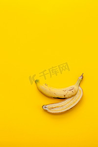在黄色背景上剥香蕉和水果