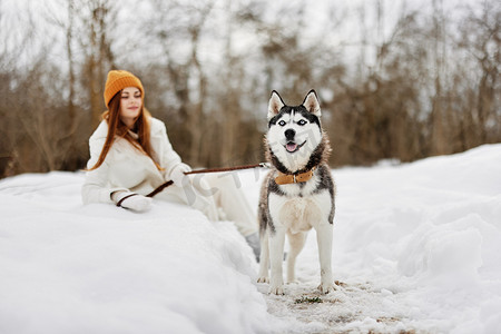 雪地里快乐的年轻女人在户外和狗玩耍友谊新鲜空气
