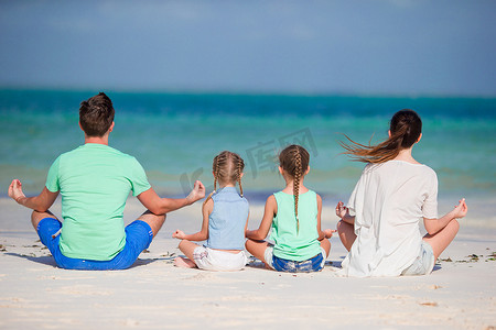 热带海滩上一个年轻家庭的背影