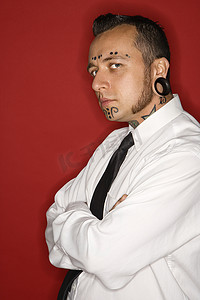 纹身肖像摄影照片_身穿衬衫和领带的纹身男子。