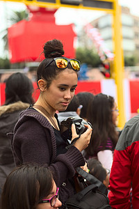 佳能相机摄影照片_秘鲁利马 Wong Parade 上拿着相机的年轻女子