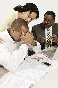 财务办公摄影照片_一位非洲裔美国女性和财务顾问在办公桌前安慰男性