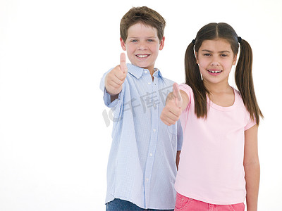儿童竖起大拇指摄影照片_兄妹俩竖起大拇指微笑
