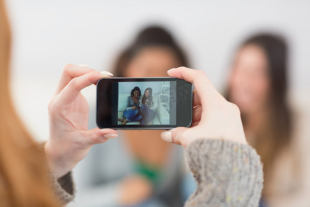 一位女士用智能手机给朋友拍照的特写