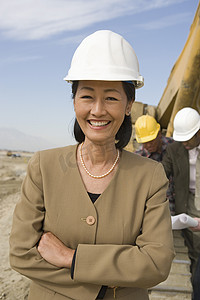 工人合影摄影照片_现场女测量员和建筑工人合影