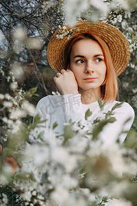 戴草帽的女孩摄影照片_樱花中戴草帽的女人画像。