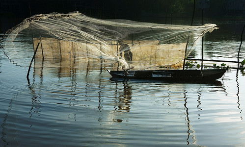 投掷摄影照片_渔夫在河上撒网