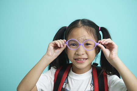 戴眼镜的特写小女学生，她漂亮可爱迷人，开朗惊讶。