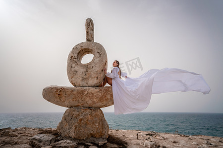 一个女人坐在由大石头制成的石雕上。