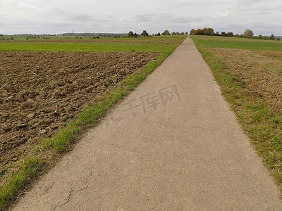 德国秋天穿过犁过的田地的长直路