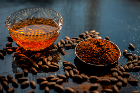 黑色木质表面抗衰老的咖啡面膜，由一些咖啡豆和蜂蜜组成。