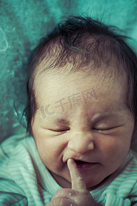 蜷缩的人摄影照片_手指，新生儿安静地睡觉，婴儿蜷缩的照片