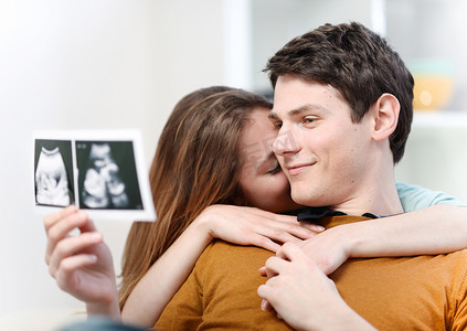 胎儿图片摄影照片_美丽的夫妇看着 th 的情感超声图片