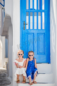 希腊米科诺斯岛典型希腊传统村庄街道上穿着裙子的快乐小女孩