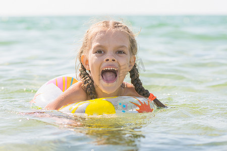 六岁女孩在海中沐浴，张大嘴巴欣喜若狂