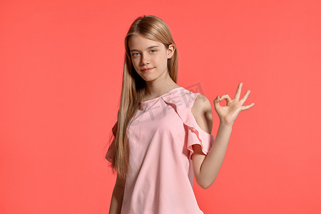 一个漂亮的金发少女的画室肖像，身穿玫瑰色 T 恤，背景为粉红色。