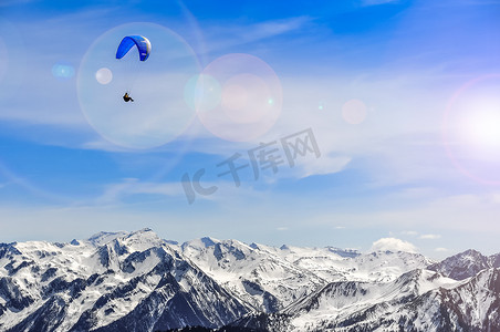 一鸟一伞摄影照片_冬天山风景和人滑翔伞