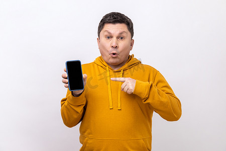 男人用手指指着空屏幕的智能手机，用震惊的表情看着相机。