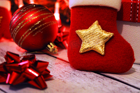 圣诞红摄影照片_圣诞红金背景，带球、蝴蝶结、圣诞袜和礼物