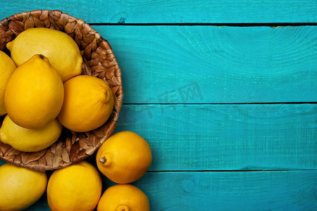 黄色青色摄影照片_在明亮的青色背景上的柠檬