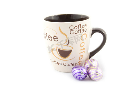 紫色文字摄影照片_杯子里放着文字咖啡，旁边放着一些巧克力东蛋