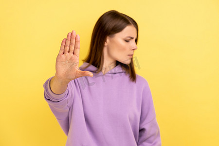 女人用手掌展示停止手势，试图阻止施虐者、拒绝。