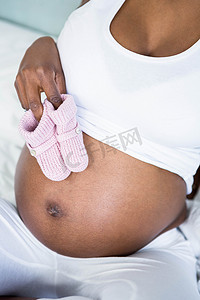 颠簸摄影照片_孕妇在颠簸处拿着婴儿鞋