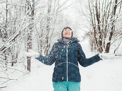 微笑的女人正在玩雪。