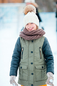 雪天摄影照片_可爱的小女孩在冬天的雪天去户外滑冰