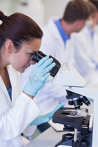 在实验室中使用显微镜的女科研人员