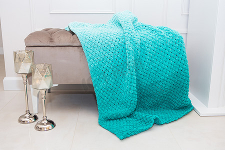 海蓝宝石绿色毛绒织物的背景质地，小沙发上柔软羊毛材料的背景图案以及烛台，舒适的概念。