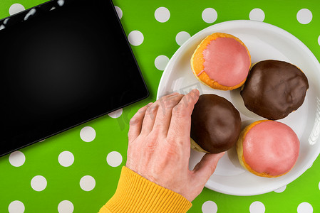 从盘子里手工挑选甜甜圈和甜巧克力面