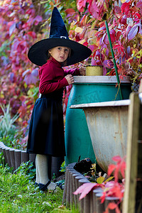 穿着女巫服装的小女孩在万圣节派对上干扰了药水