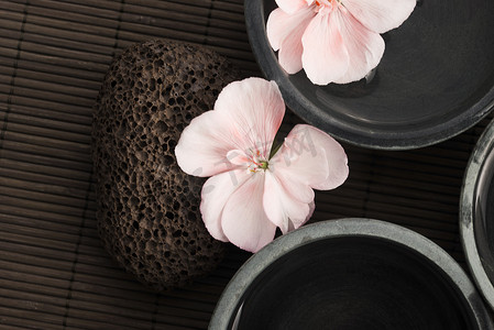 花朵石头摄影照片_Spa 静物画，有粉红色的花朵、石头和水