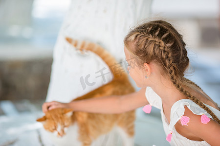 希腊米科诺斯岛希腊村庄玩猫的小可爱女孩的特写