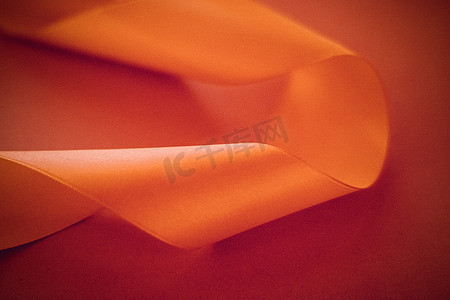 在橙色背景的抽象卷曲丝带，专属豪华