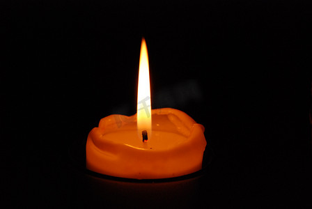照亮黑暗摄影照片_一根蜡烛照亮了黑暗。
