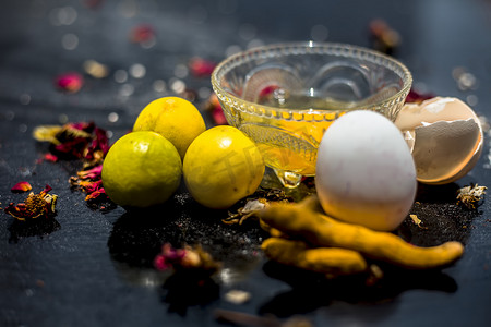 柠檬汁、蜂蜜和凝乳的面膜，以及一些生姜黄在玻璃碗中与木质表面上的所有原料充分混合，用于易长粉刺的皮肤和瑕疵。