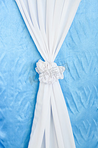 蓝色背景上的白色窗帘丝带