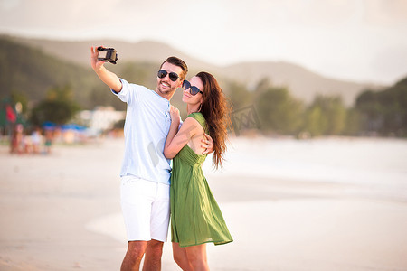 蜜月假期在白色沙滩上拍照的幸福情侣