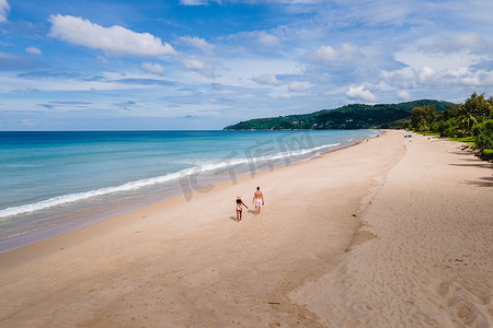 在泰国普吉岛卡伦海滩散步的情侣的无人机视图