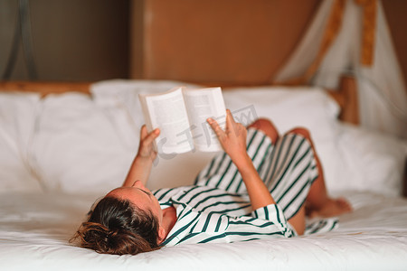 美丽的女人在床上看书放松