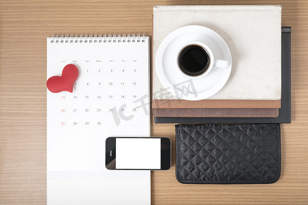 叠杯子摄影照片_办公桌：带电话的咖啡、钱包、日历、心形、一叠 b