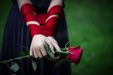 针织女手拿着红玫瑰