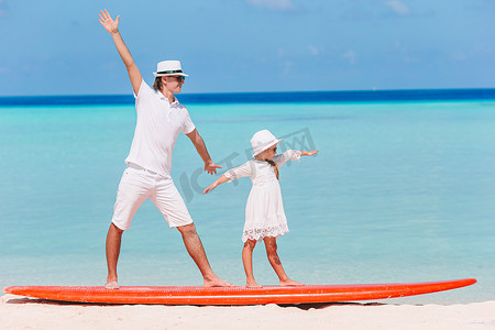 暑假期间爸爸和孩子在冲浪板上的家庭